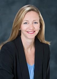 Smiling woman in a blue shirt and black blazer