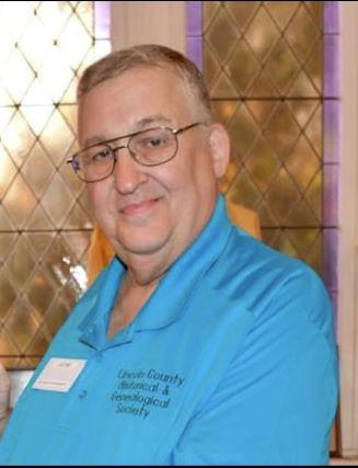 Man in blue shirt with glasses